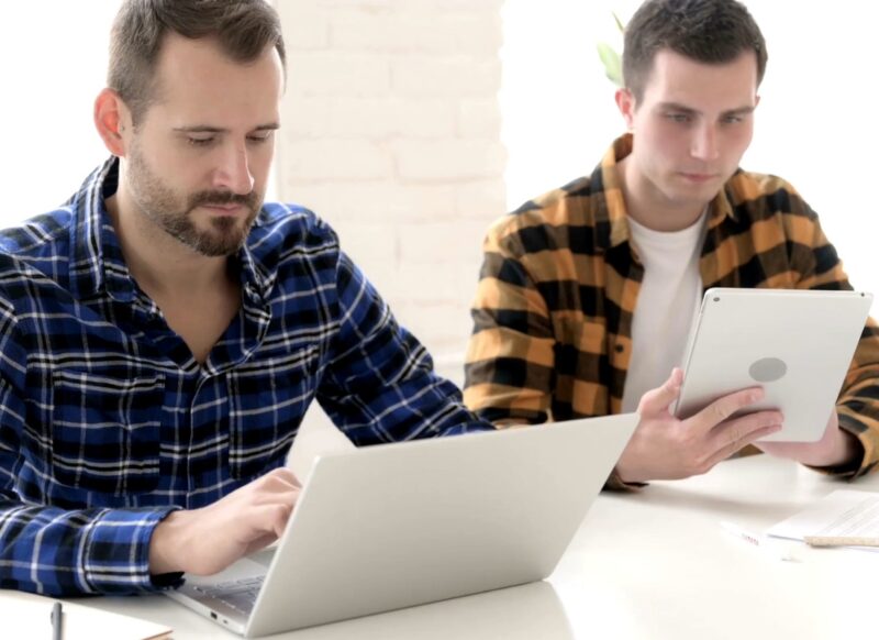 dva momka rade za laptopom i tabletom