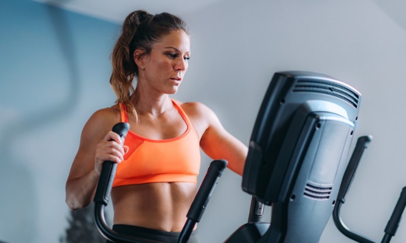 Žena vežba na eliptičnom kros trenažeru