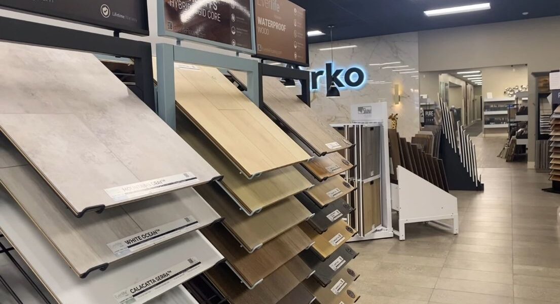 Uzorci hybrid, vinil i drvenih podnih obloga pored belog kuhinjskog elementa.