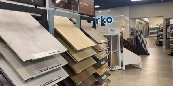 Uzorci hybrid, vinil i drvenih podnih obloga pored belog kuhinjskog elementa.