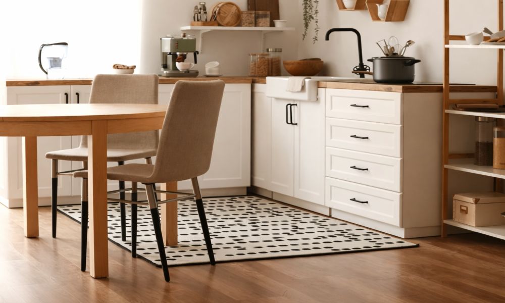 Kuhinja sa drvenim podom i dekorativnim tepihom ispod trpezarijskog stola