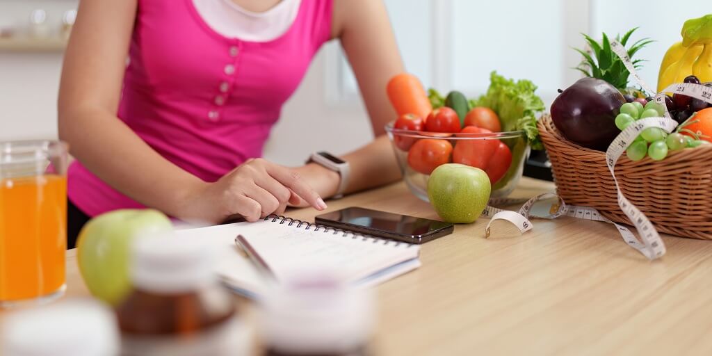 Planiranje obroka uz beleške i sveže namirnice na kuhinjskom stolu