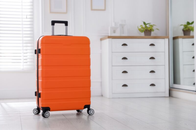 prikaz narandžastog kofera u hodniku
