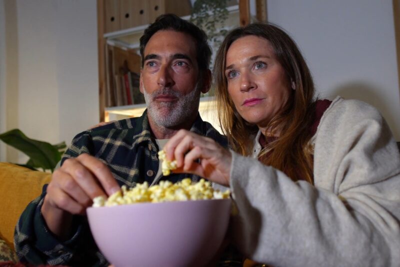 bračni par gleda film i jede kokice